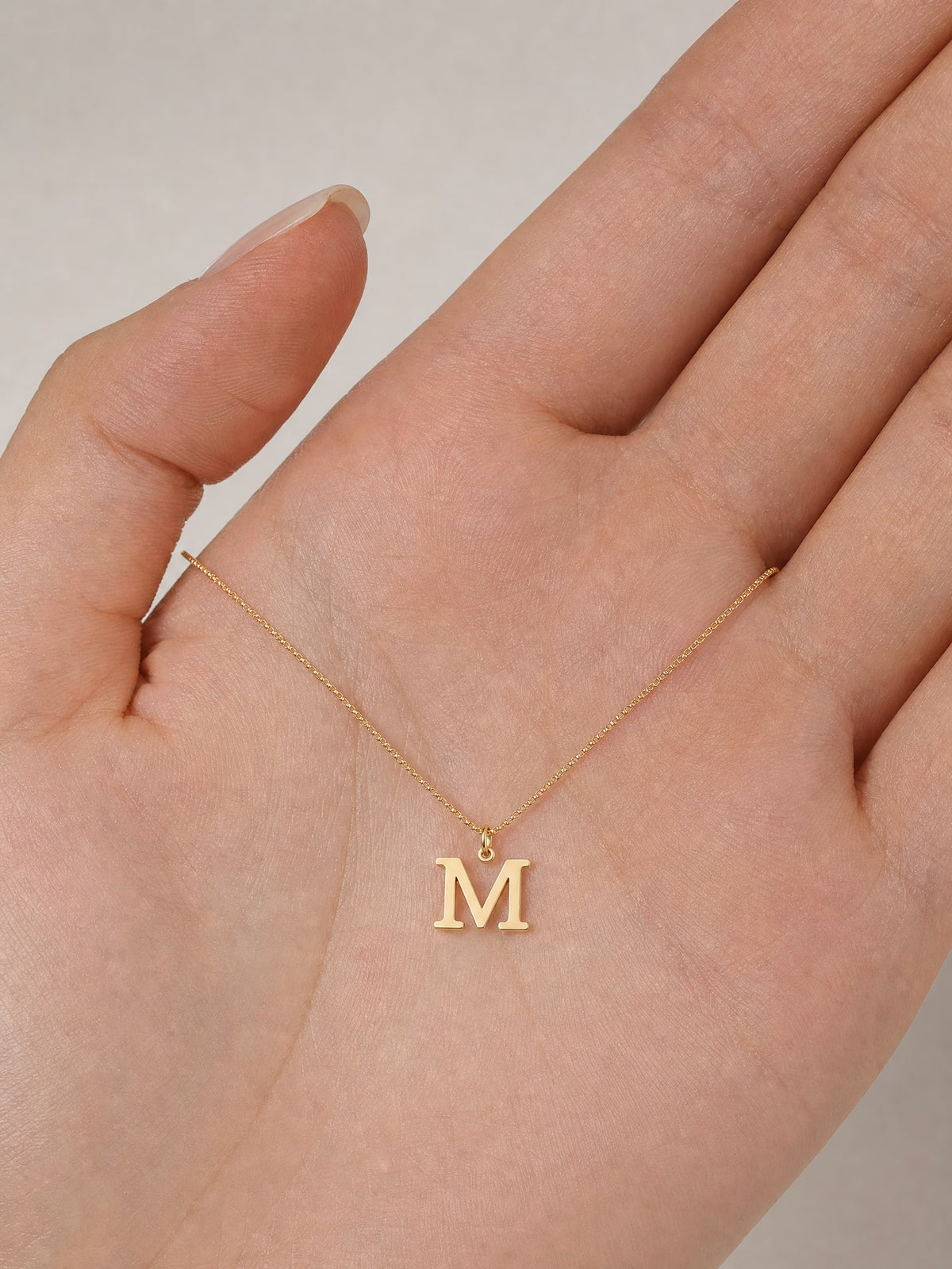 SAINT GILD initial necklace in hand