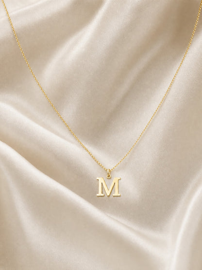 SAINT GILD initial necklace flatlay on satin