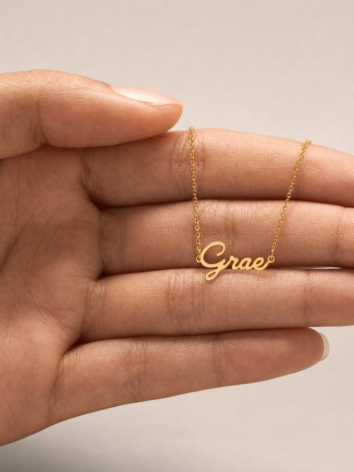 SAINT GILD name necklace in hand
