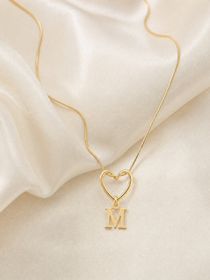 SAINT GILD initial heart necklace flatlay on satin