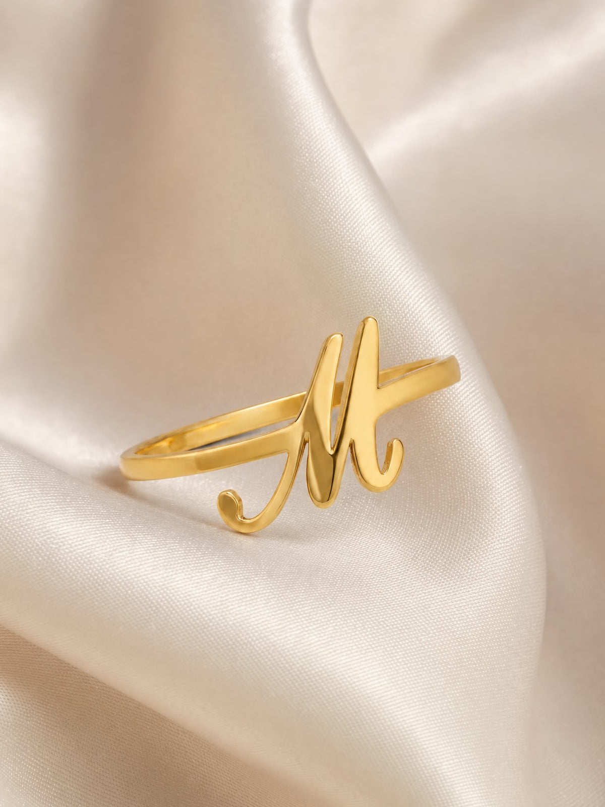 SAINT GILD initial ring flatlay on satin