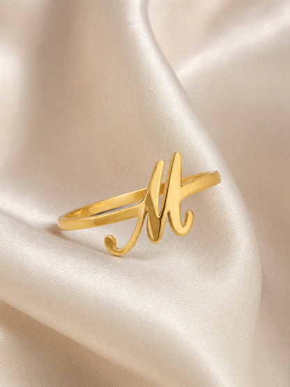SAINT GILD initial ring flatlay on satin