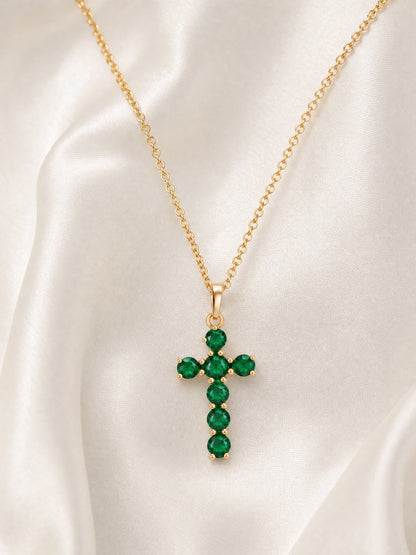SAINT GILD birthstone cross necklace flatlay on satin