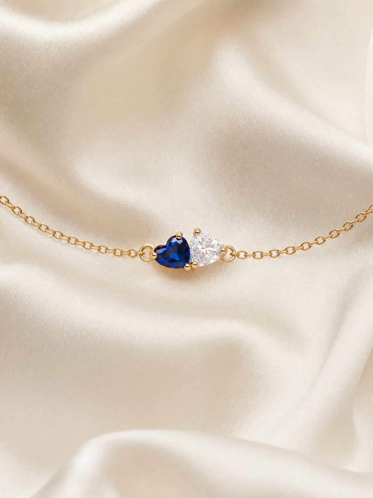 SAINT GILD two birthstone bracelet flatlay on satin