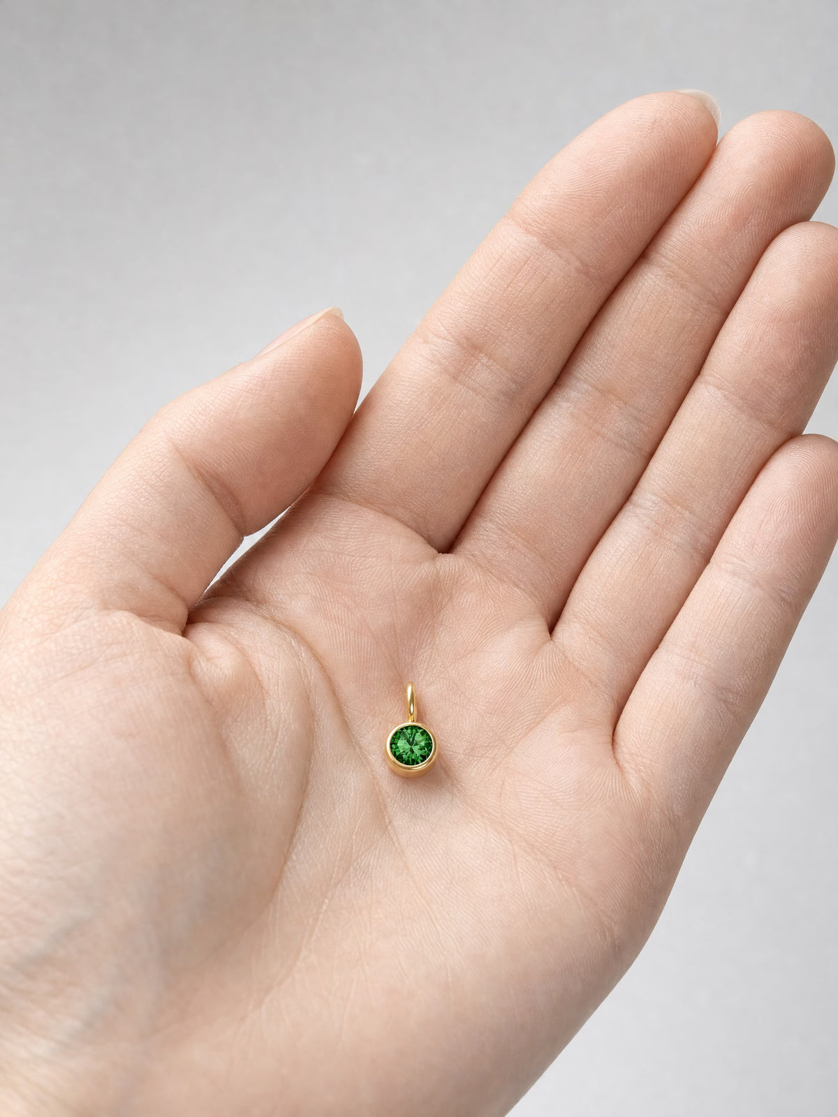 SAINT GILD birth month charm in hand