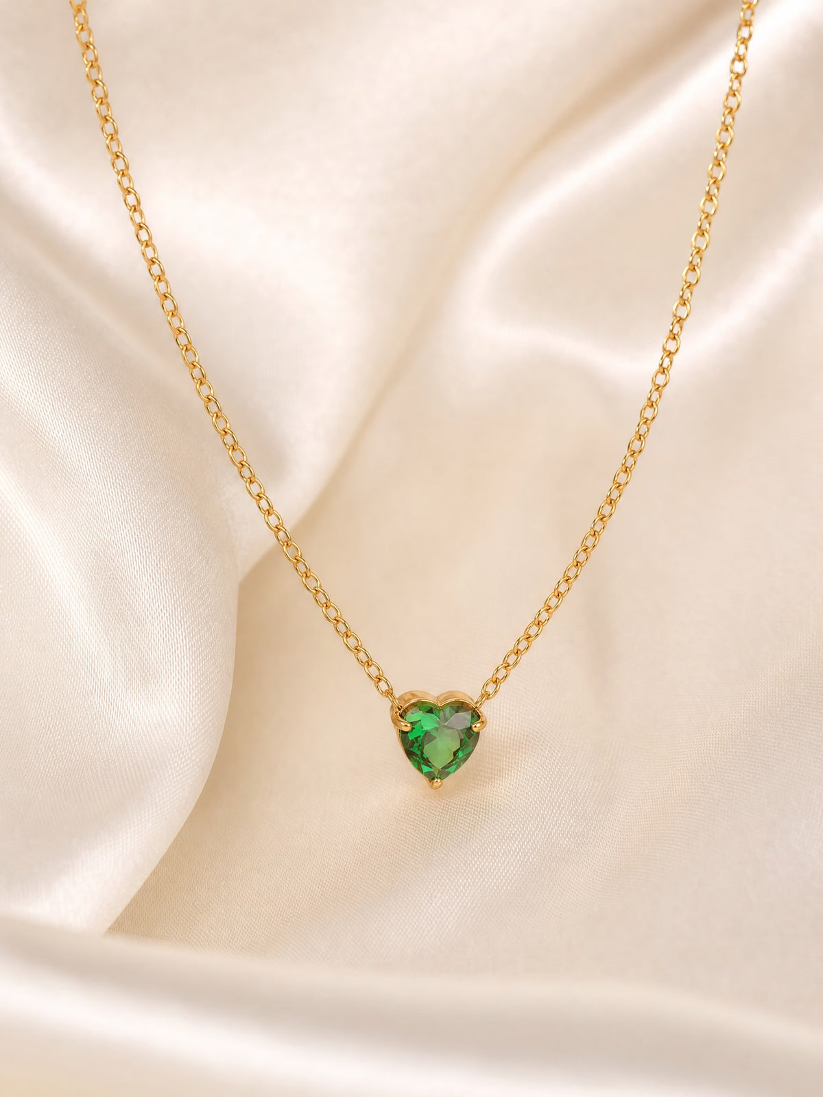 SAINT GILD birthstone heart necklace flatlay on satin